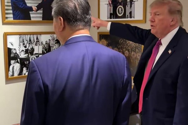 US President Donald Trump points out a framed photograph of the two leaders shaking hands on the wall of the White House in Washington to Chinese President Xi Jinping. Photo: Handout 
