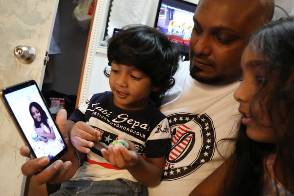 From left: Little Dinath, his dad Supun Thilina Kellapatha, and sister Sethumdi, make a video call to his half-sister Keana, 7, who is in Canada. Photo: Nora Tam