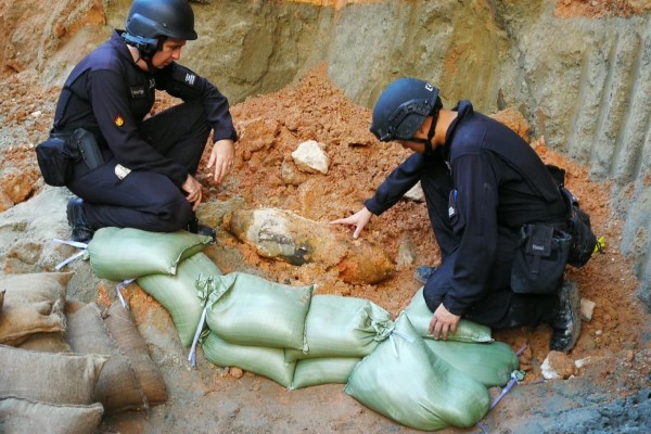 Bomb squad officers study the device found near Kai Tak MTR station. Photo: Handout