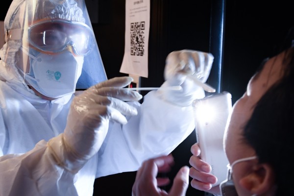 A doctor is seen doing a throat swab on a person at a health observation point in the Longgang District of Shenzhen, in southern China's Guangdong province. Photo: Xinhua