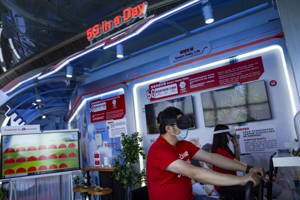 Staff demonstrate a VR cycling system during a media tour of SmarTone 5G Lab at Sky 100 at the International Commerce Centre in Hong Kong on May 1. Telecoms companies are betting on virtual and augmented reality to help recoup the costs of building 5G networks. Photo: SCMP/Sam Tsang