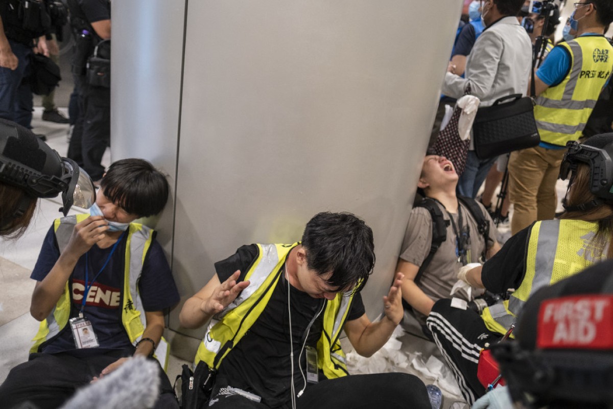 Members of the media react after pepper spray was deployed by police during a protest inside the International Finance Center (IFC) Mall in Central. Photo: Bloomberg