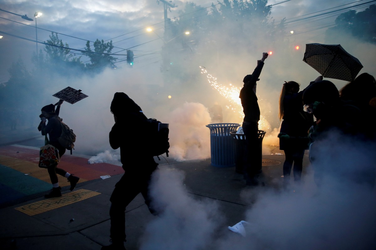 Protesters disperse as tear gas, pepper spray and flash-bang devices are deployed by Seattle police during a protest against police brutality and the death in Minneapolis police custody of George Floyd, in Seattle, Washington.
