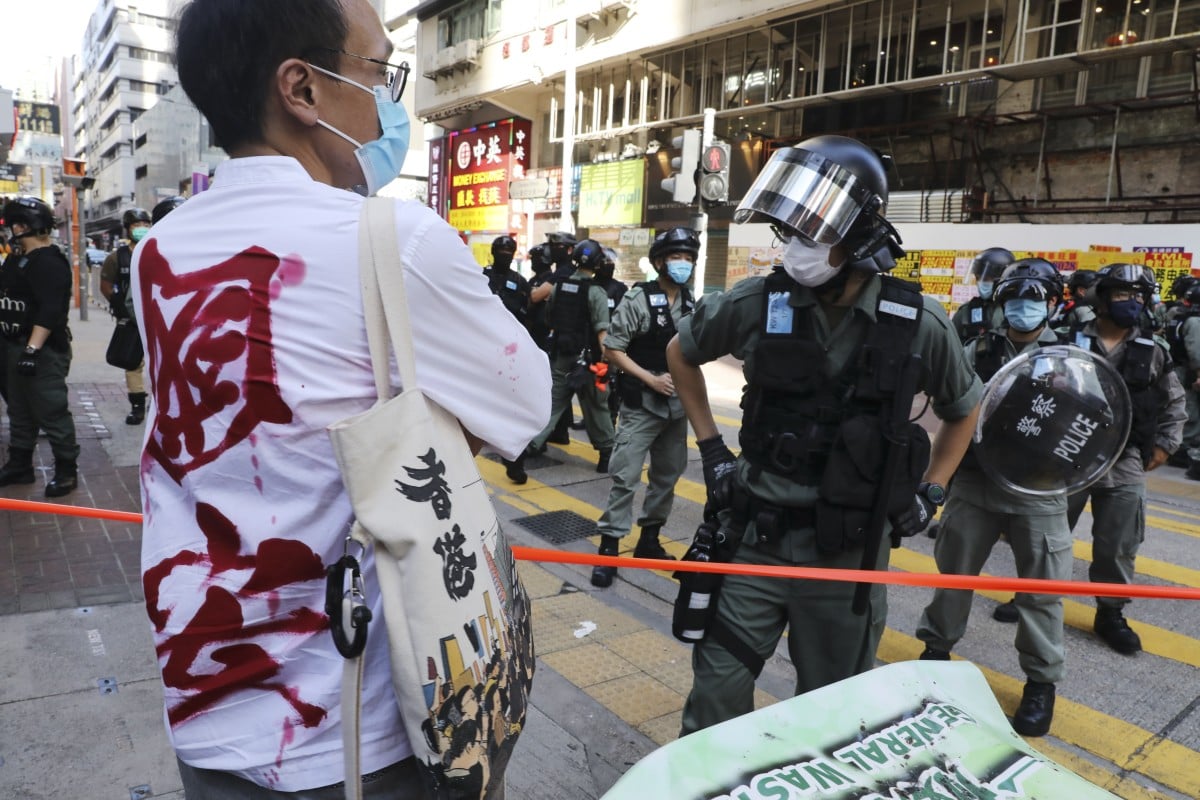 A man wears a shirt with Chinese characters which read "national security" as riot police disperse protesters during a silent march from Jordan along Nathan Road to Mong Kok in protest against the national security law. Photo: SCMP/Dickson Lee