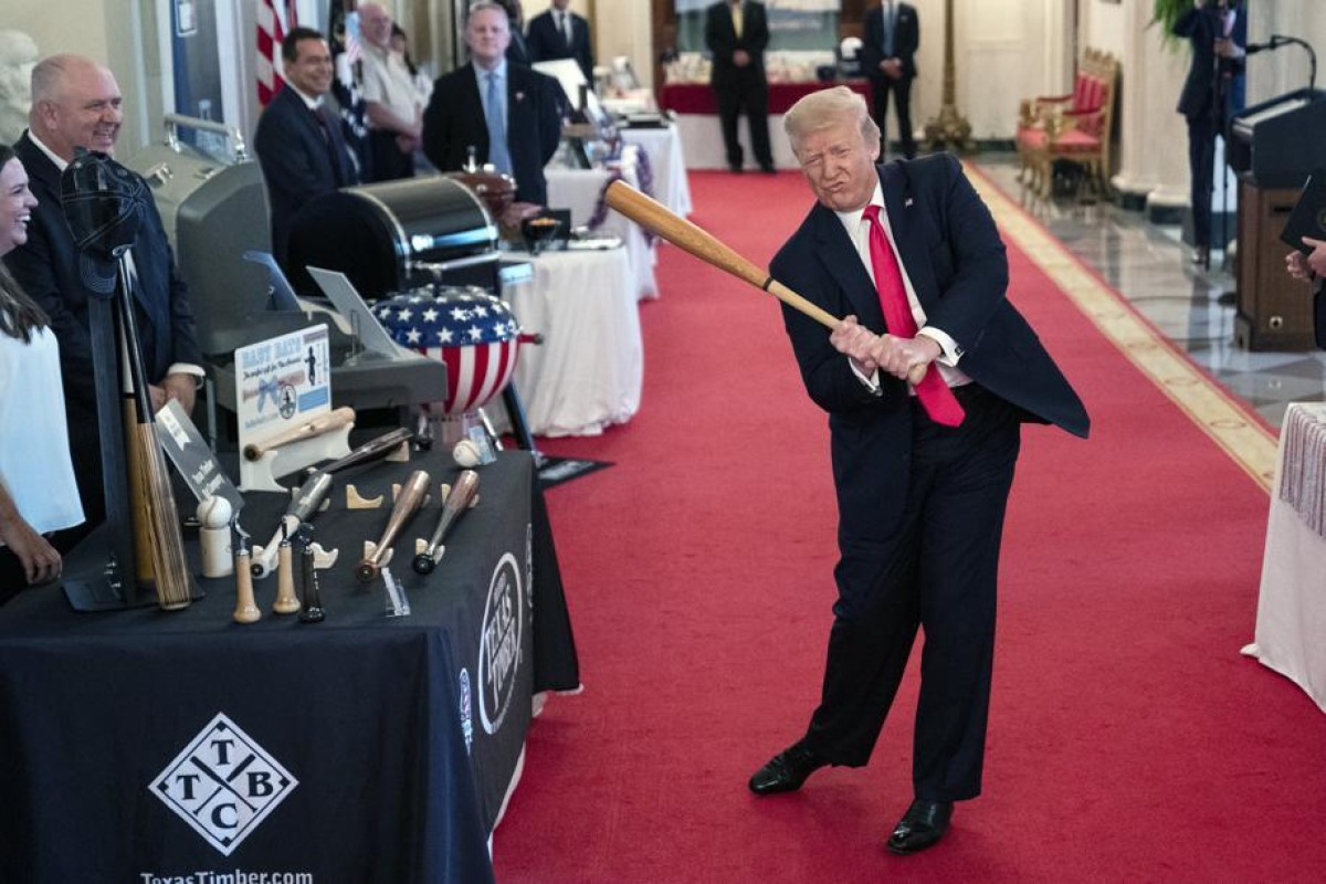 President Donald Trump swings a baseball bat during the Spirit of America Showcase at the White House. Photo: AP