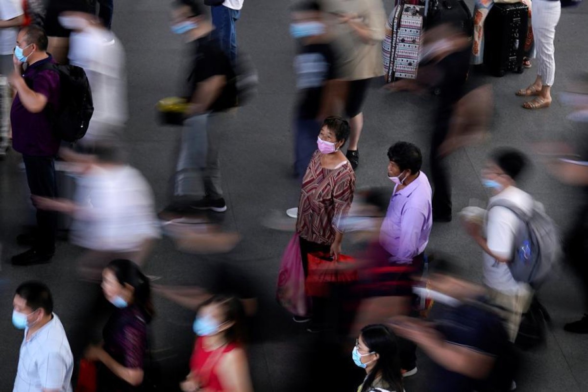 People wearing face masks wait for the train at Suzhou Railway Station in China. Photo: Reuters