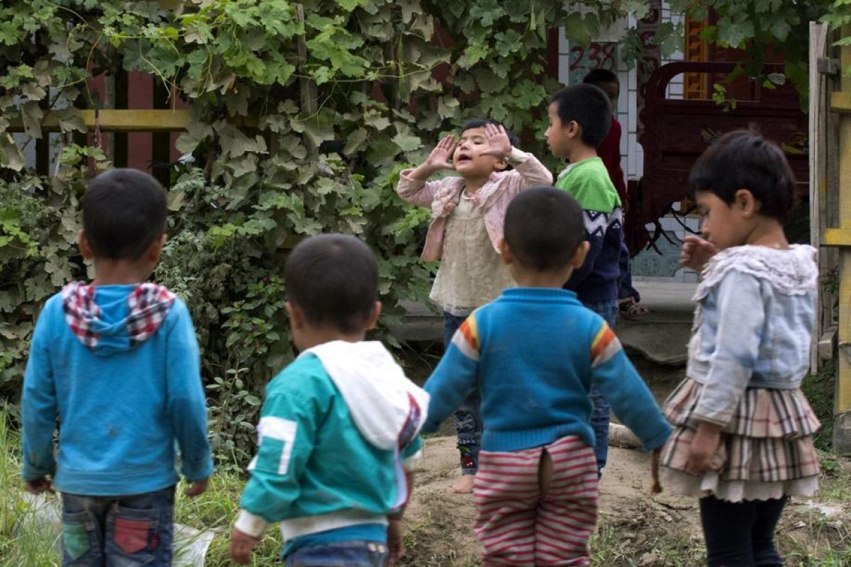 Uygur children play outdoors in Hotan, in western China's Xinjiang region. The Associated Press has found that the Chinese government is carrying out a birth control program aimed at Uygurs, Kazakhs and other largely Muslim minorities in Xinjiang, even as some of the country's Han majority is encouraged to have more children. Photo: AP