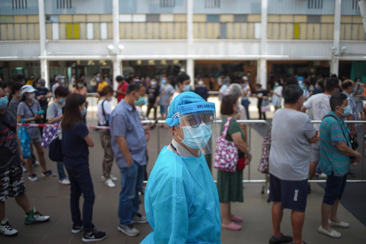 Residents submit their deep-throat saliva sample for testing of the virus at Yuk Shek House, Ping Shek Estate. Photo: SCMP/ Winson Wong