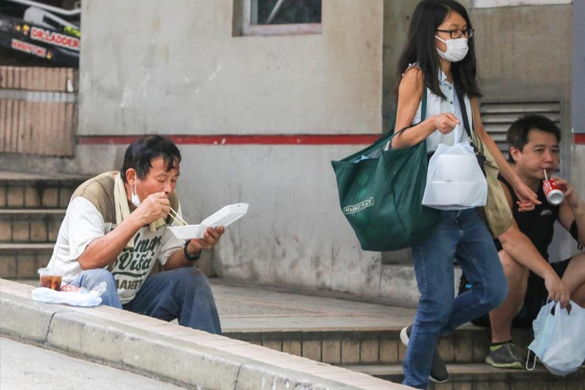 People eat their meals on the street in Central on Wednesday after the complete ban on dining in restaurants took place. Photo: SCMP/May Tse