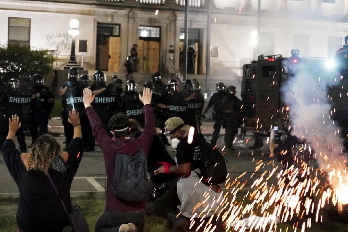 Police attempt to push back protesters outside the Kenosha County Courthouse in Kenosha, Wisconsiin. Protesters converged on the county courthouse during a second night of clashes after the police shooting of Jacob Blake a day earlier turned Kenosha into the nation's latest flashpoint city in a summer of racial unrest. Photo: AP