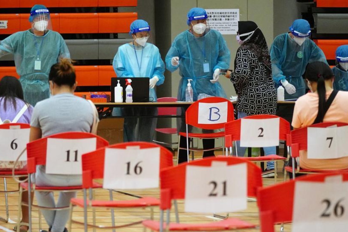 Domestic helpers wait to be tested at the Harbour Road Sports Centre in Wan Chai. Photo: SCMP/ Sam Tsang