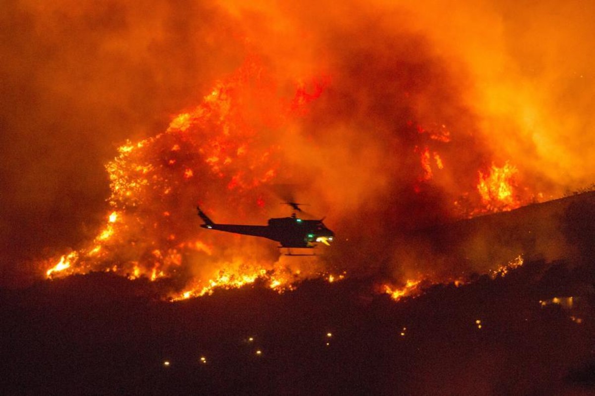 A helicopter prepares to drop water at a wildfire in Yucaipa, California. A couple’s plan to reveal their baby’s gender at a party went up in smoke Saturday at El Rancho Dorado Park in Yucaipa, when a pyrotechnical device they used sparked a wildfire that has burned thousands of acres. Photo: AP