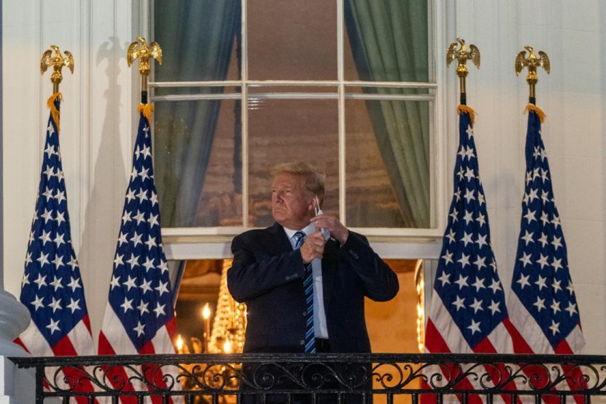 US President Donald Trump removes his protective mask at the White House , after his release from hospital. Photo: Bloomberg