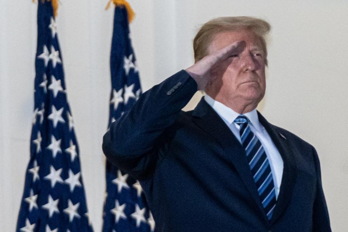 US President Donald Trump salutes after taking off his mask on returning to the White House. Photo: EPA-EFE