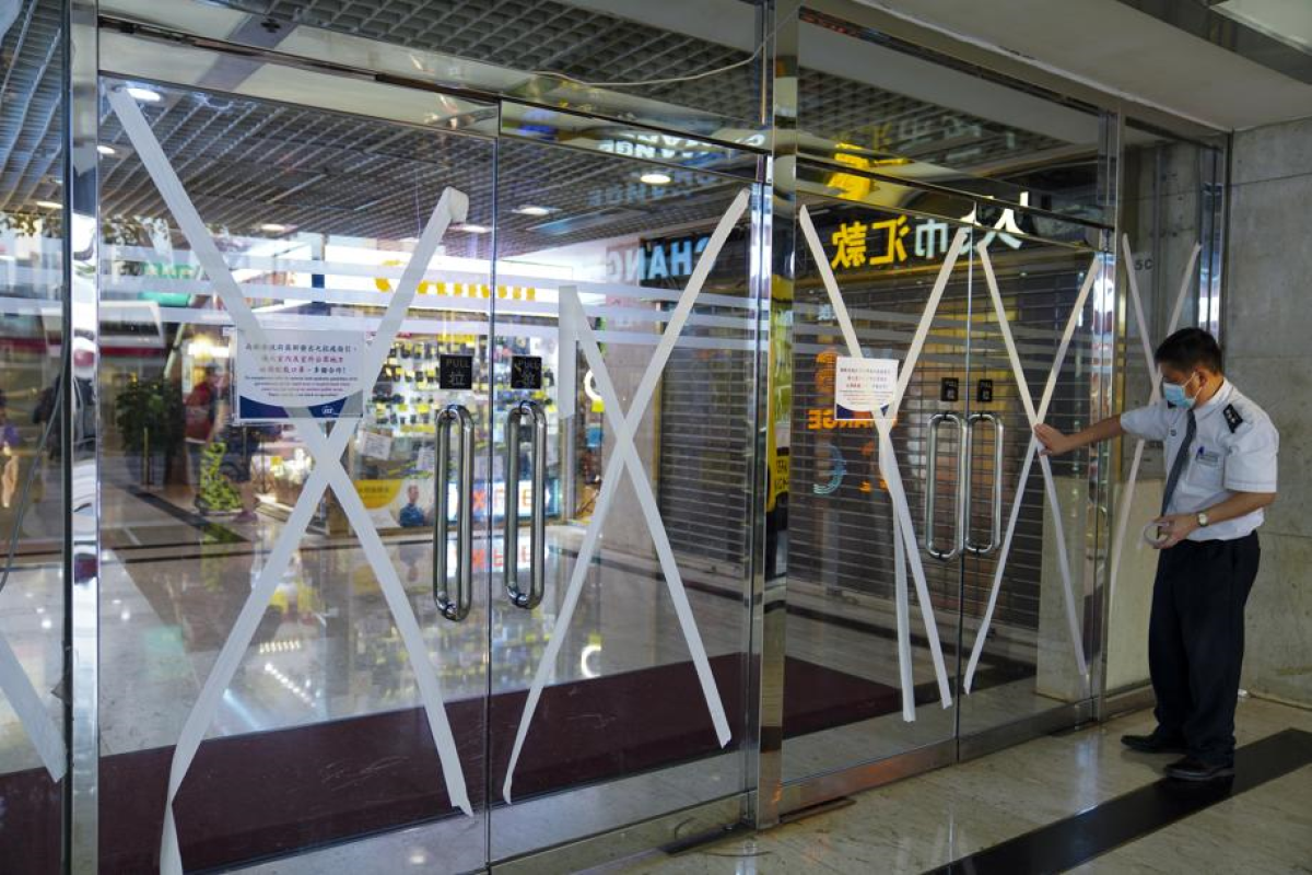 Staff tape the entrance to Star House in Tsim Sha Tsui as the storm gains momentum. Photo: SCMP/ Sam Tsang