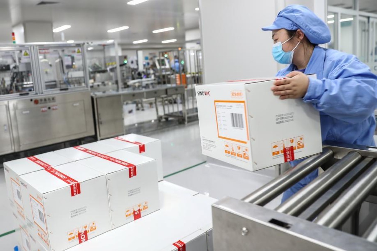 A Sinovac employee handles a box of the company’s coronavirus vaccine, officially approved for use in Hong Kong on Thursday. Photo: Xinhua