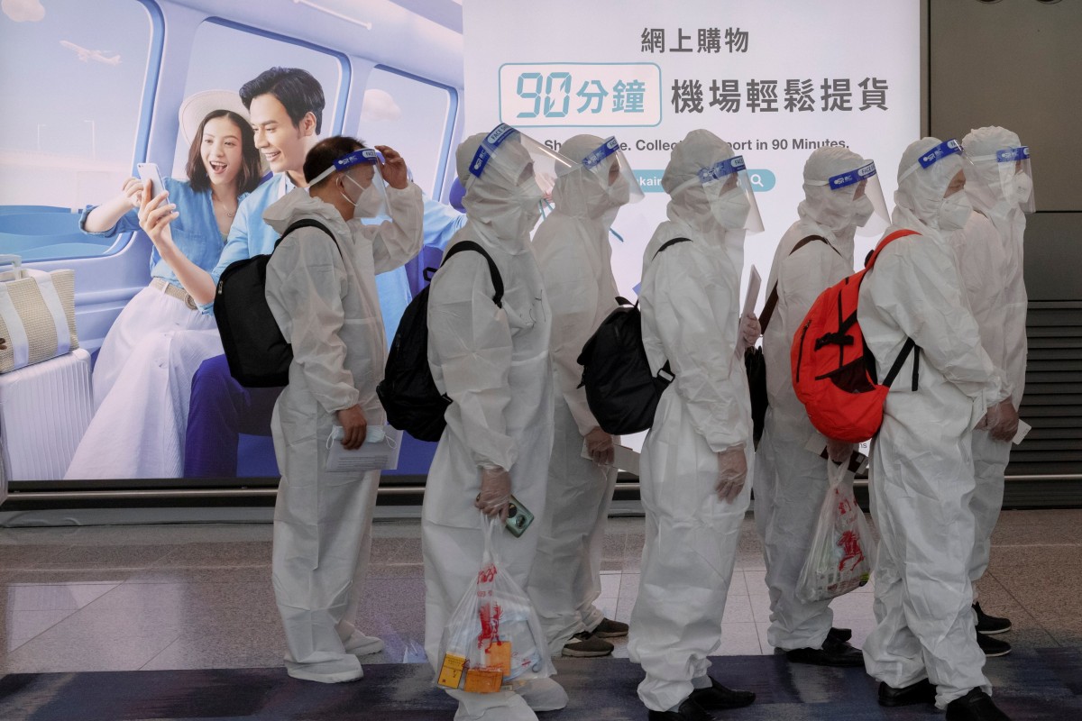 Passengers wearing protective suits (PPE) line up to board their plane for an international flight at Hong Kong International Airport amid the spread of the coronavirus in July 2021. Photo: Reuters