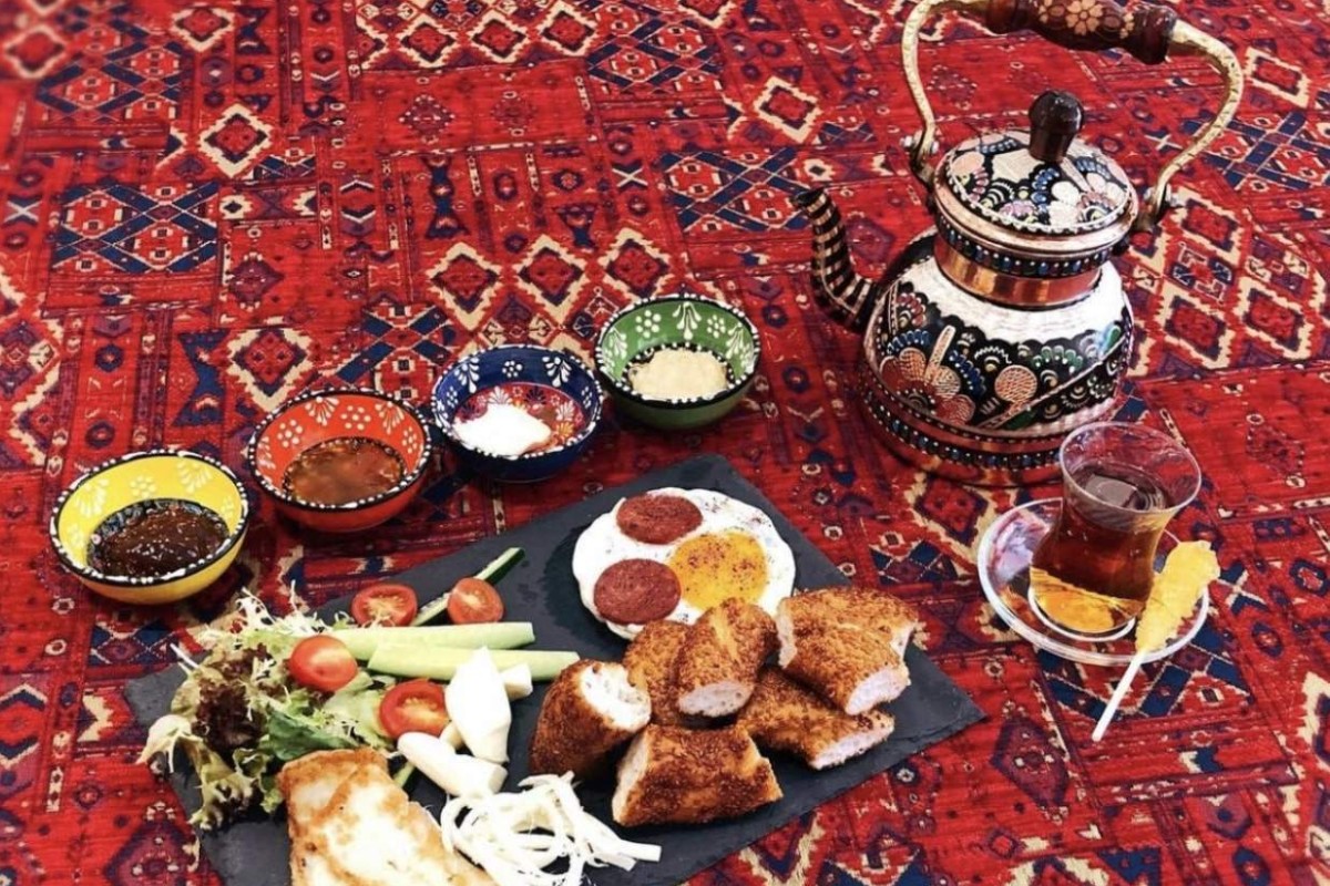 The Turkish Breakfast set in full view, including four dips, simit, cheese, egg, Turkish tea, and salad. Photo: @lonelypaisley on Instagram