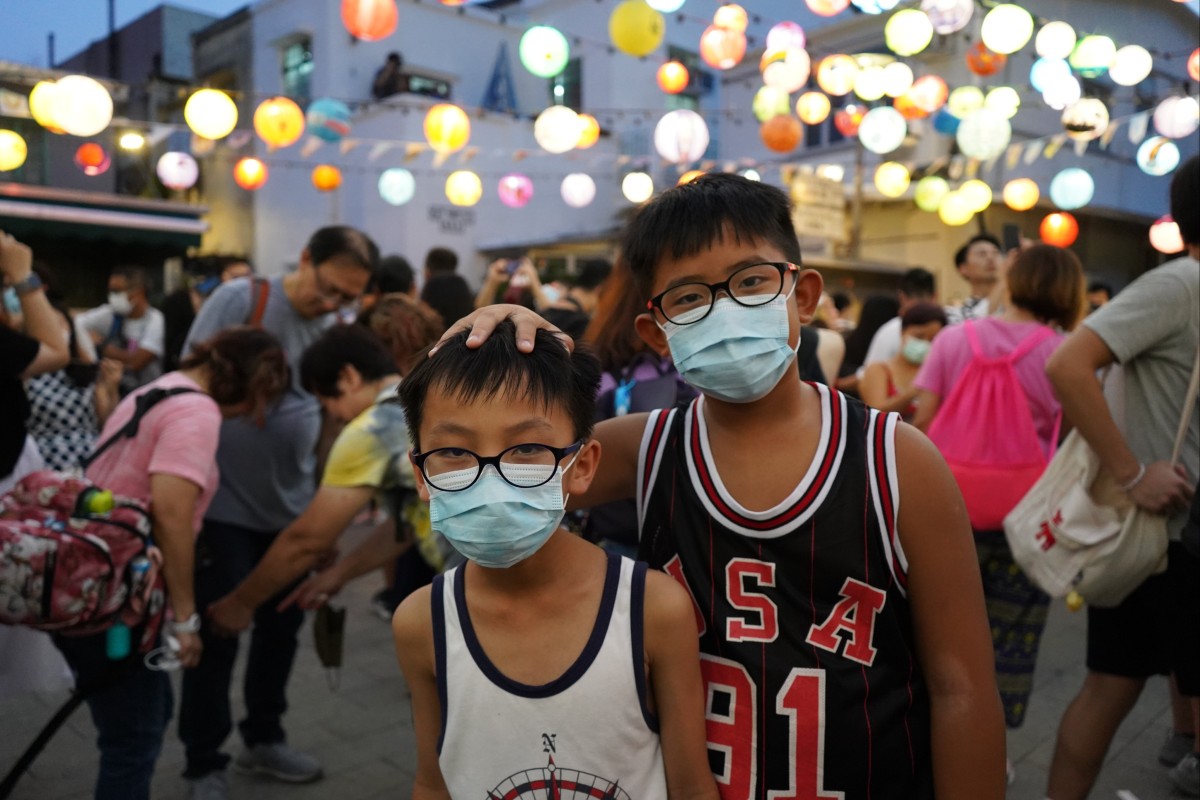 Lau Hin-chit, right, poses with his cousin at the Tai O lantern Festival. He’s one of many volunteers who painted a lantern for the celebrations. Photo: SCMP/Sue Ng