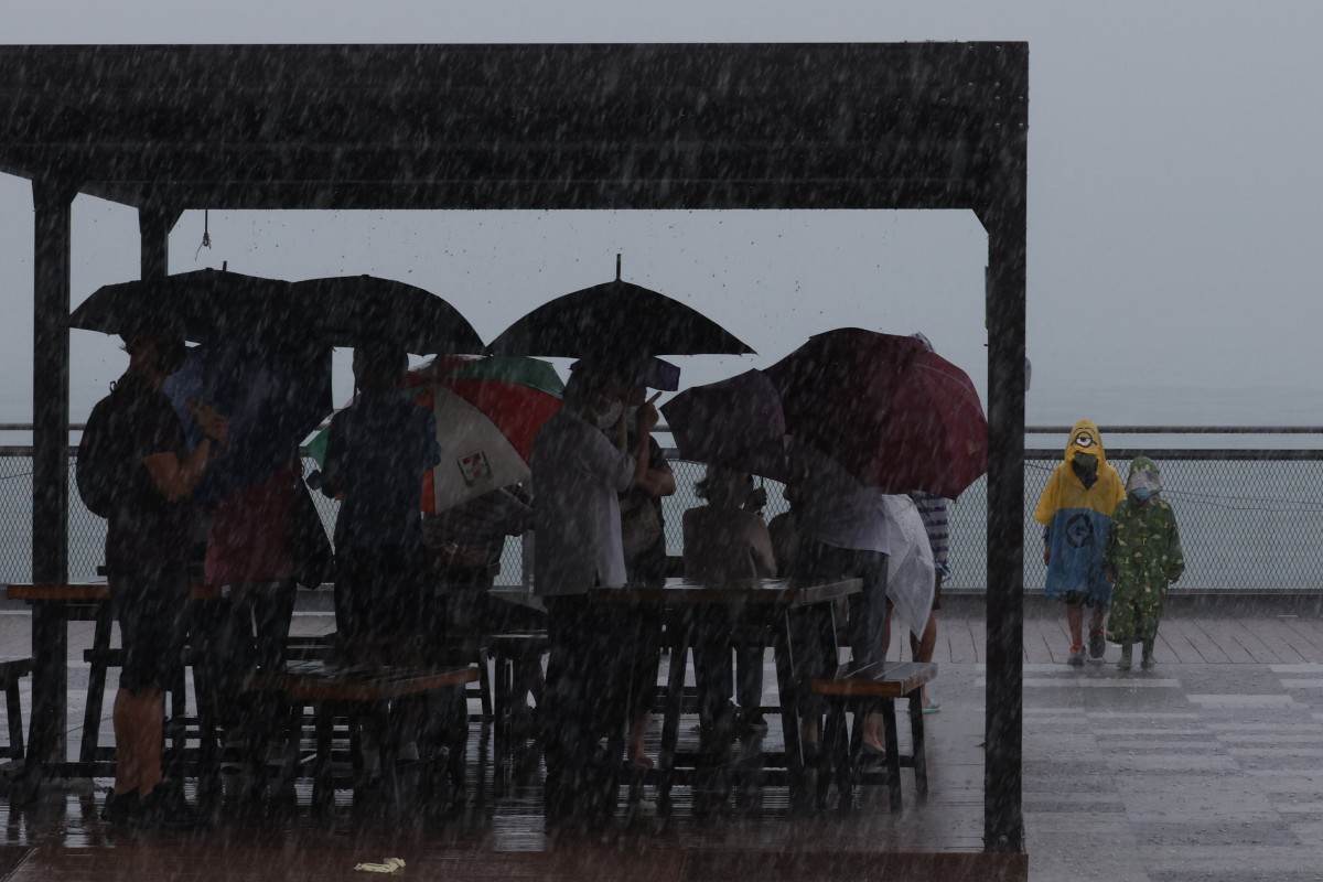 People feel the heavy rain and strong winds at Kennedy Town waterfront under typhoon signal No 8 as Kompasu hits Hong Kong. Photo: SCMP / Nora Tam