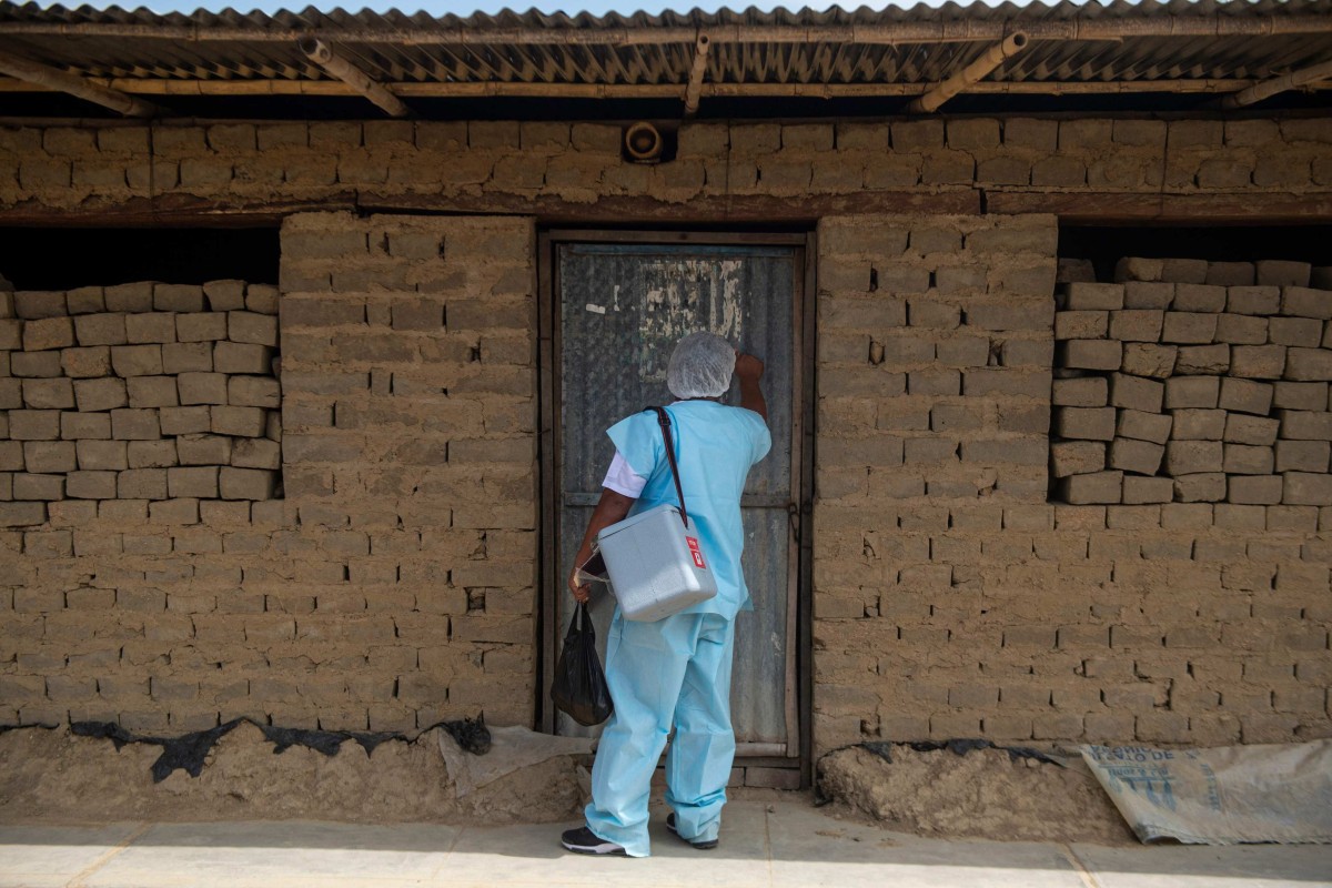 A health worker knocks on a door in Peru, where people over 24 years of age are being vaccinated with the AstraZeneca/Oxford vaccine against coronavirus. Peru has exceeded 200,000 deaths from the novel coronavirus, the Ministry of Health reported on October 22, 2021, making it the country with the highest global fatality rate per capita from the disease. Photo: AFP