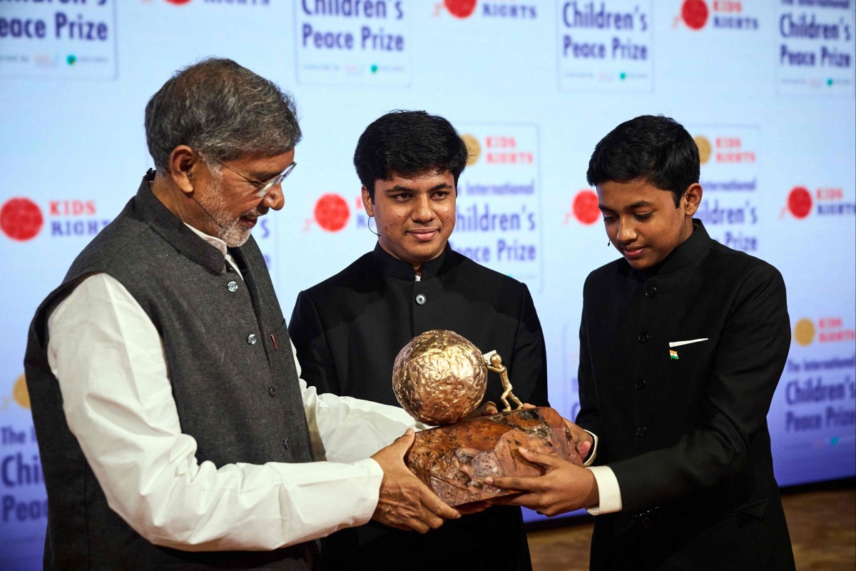 Nobel Peace Prize winner 2014 Kailash Satyarthi (L) presents the International Children’s Peace Prize 2021 to Vihaan and Nav Agarwal. Photo: AFP