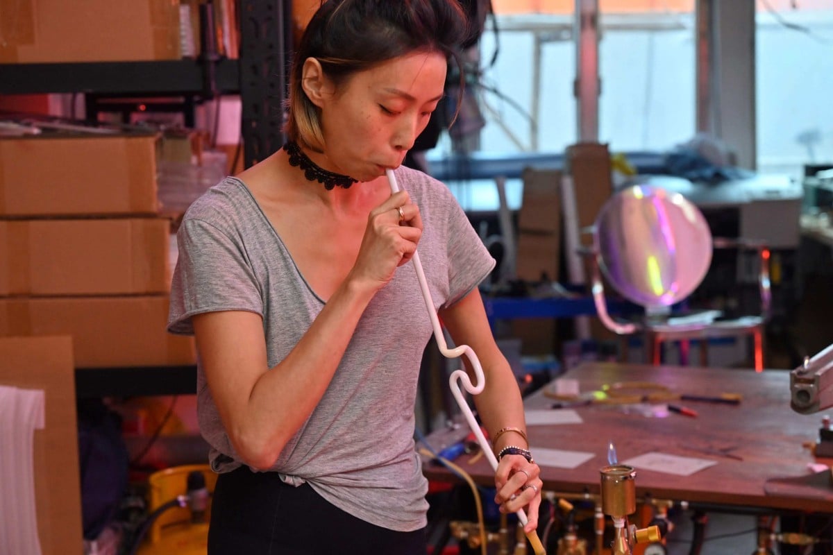 Neon artist Karen Chan blowing into a neon glass tube at a studio in Hong Kong. Photo: AFP