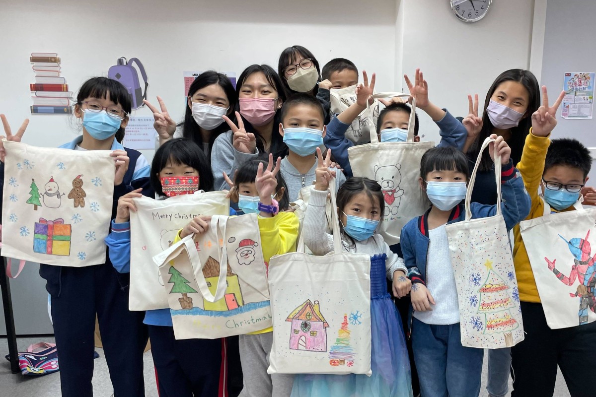 Children hold up their finished bags at the Christmas tote bag workshop organised by SimplyShare. Photo: Handout