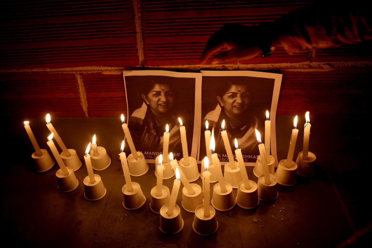 Fans light candles in front of photographs of legendary singer Lata Mangeshkar during a vigil in Bangalore, India. She passed away on Sunday at the age of 92 after being treated for Covid-19 and pneumonia symptoms for nearly a month. Photo: EPA-EFE