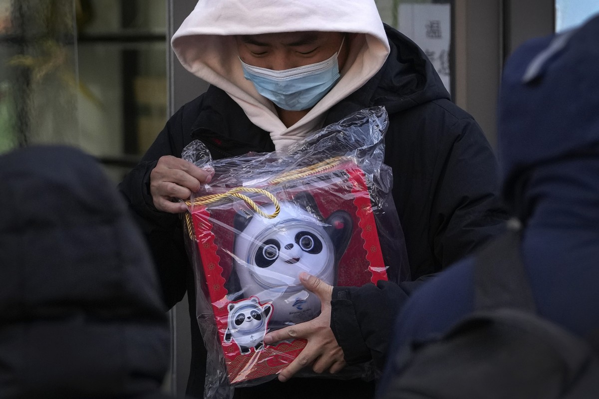A man holds the Olympic mascot Bing Dwen Dwen doll which he purchased form a store selling 2022 Winter Olympics memorabilia in Beijing. Photo: AP