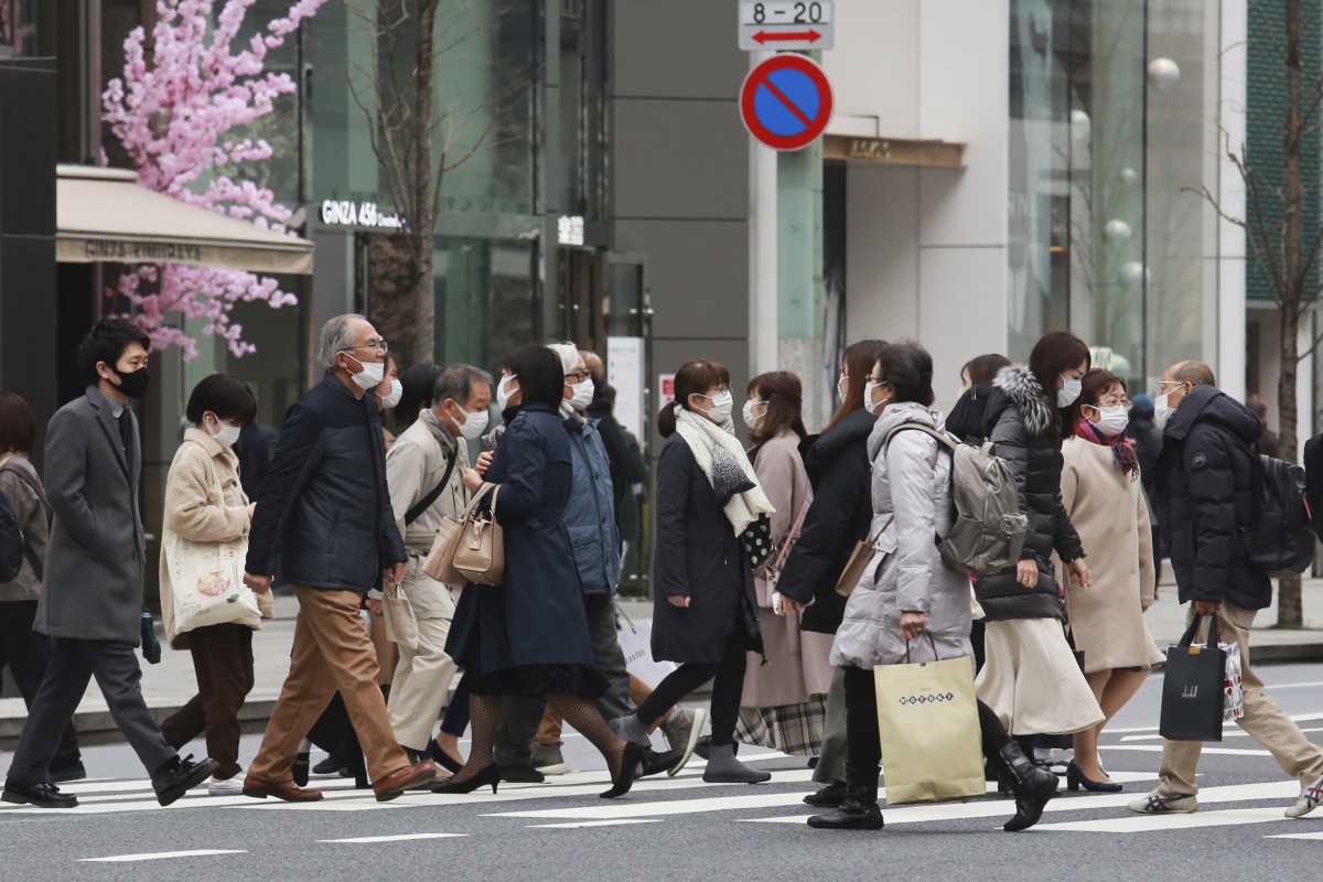 People wear face masks to protect against the spread of the coronavirus in Tokyo as the pandemic enters its third year. Photo: AP