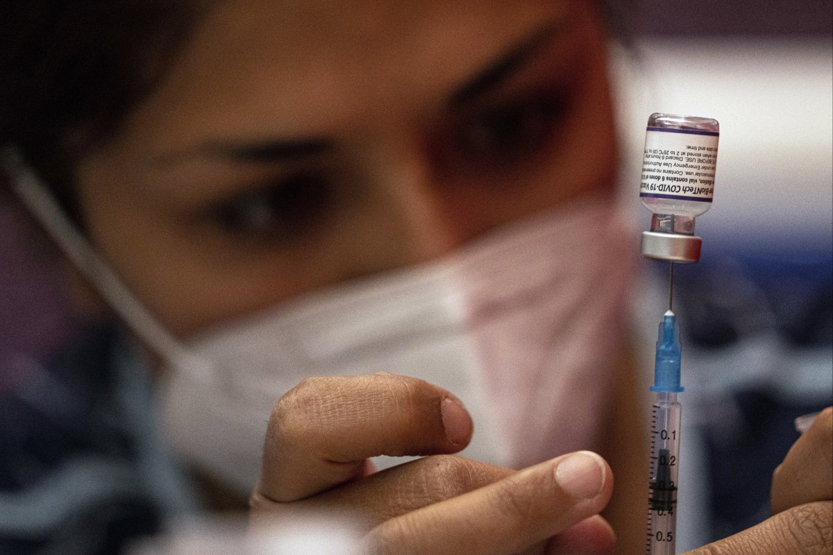 A health worker prepares doses of the Pfizer Covid-19 vaccine at a booster shot campaign in Santiago, Chile. Photo: AP