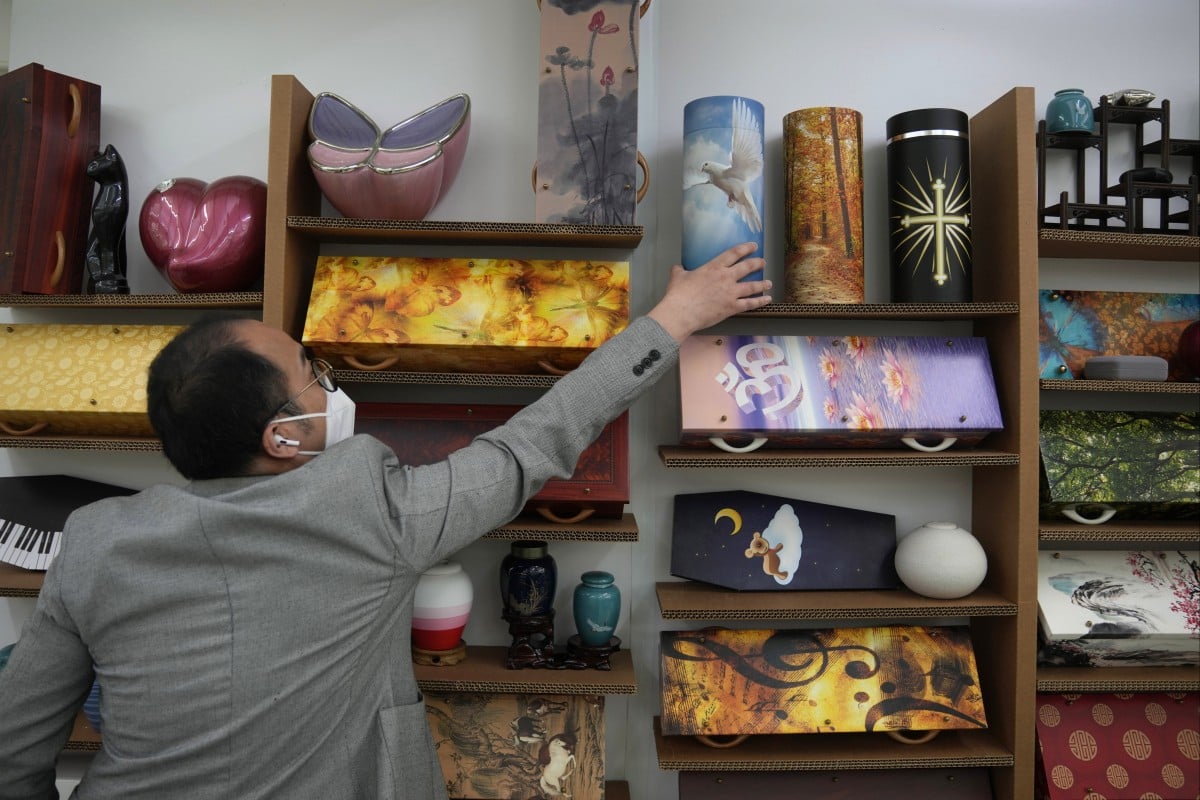 Wilson Tong, CEO of LifeArt Asia, stands with models of eco-friendly paper coffins at the LifeArt factory in Aberdeen. Photo: AP
