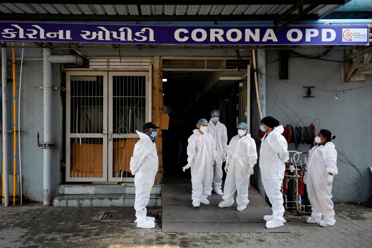 Healthcare workers wearing personal protective equipment (PPE) stand at the entrance of a coronavirus hospital in Ahmedabad, India in January 2022. Photo: Reuters