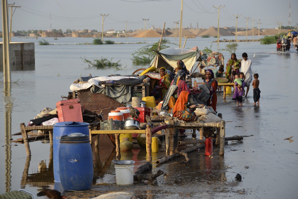 Families sit near their belongings surrounded by floodwaters in Sohbat Pur city of Jaffarabad, a district of Pakistan’s southwestern Baluchistan province on Sunday. Roughly one-third of Pakistan is underwater after severe flooding. Photo: AP