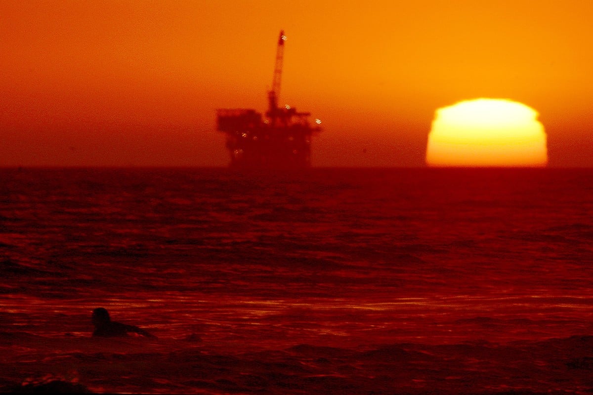 A surfer paddles out at Huntington Beach in the US state of California, where temperatures are expected to climb as high as 46 degrees Celsius. Many countries around the world are going through heat waves. Photo: TNS