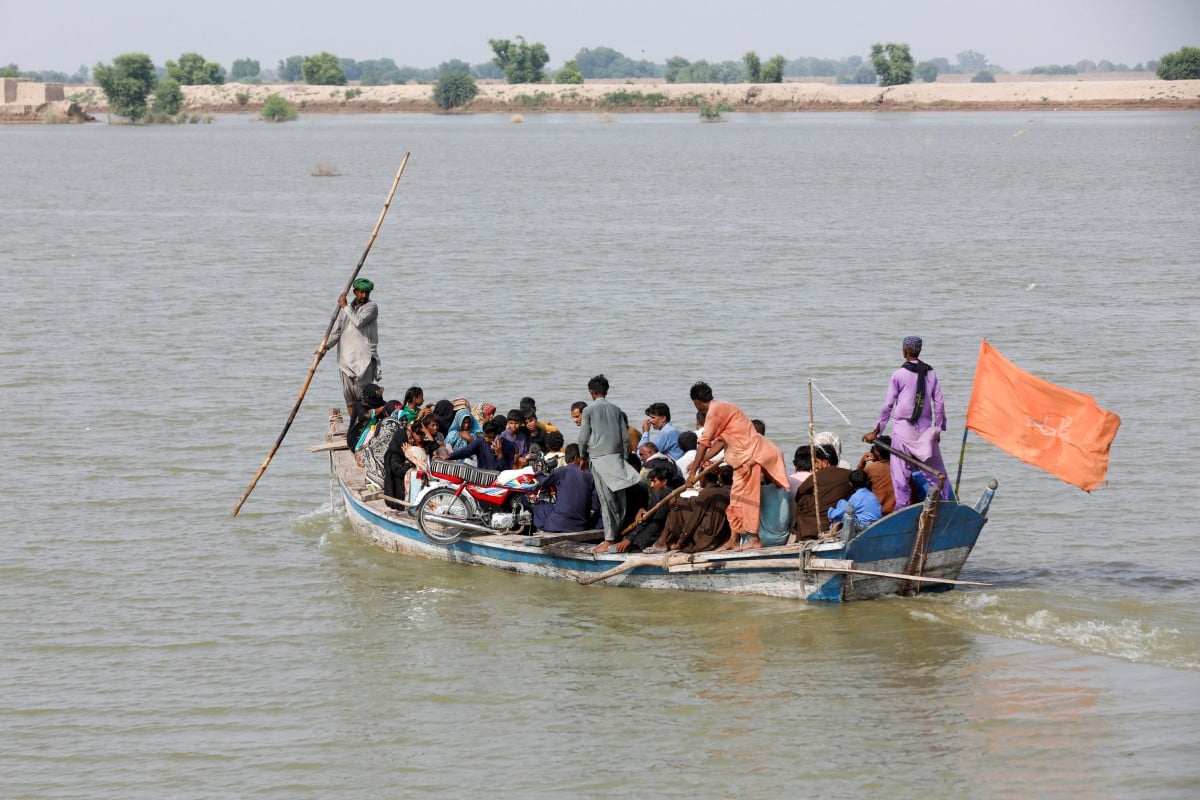 Residents travel in a boat through flood water while heading to their villages, following rains and floods during the monsoon season in Sehwan, Pakistan. The world can expect more extreme weather like these floods if it doesn’t work to fight climate change, the UN said. Photo: Reuters