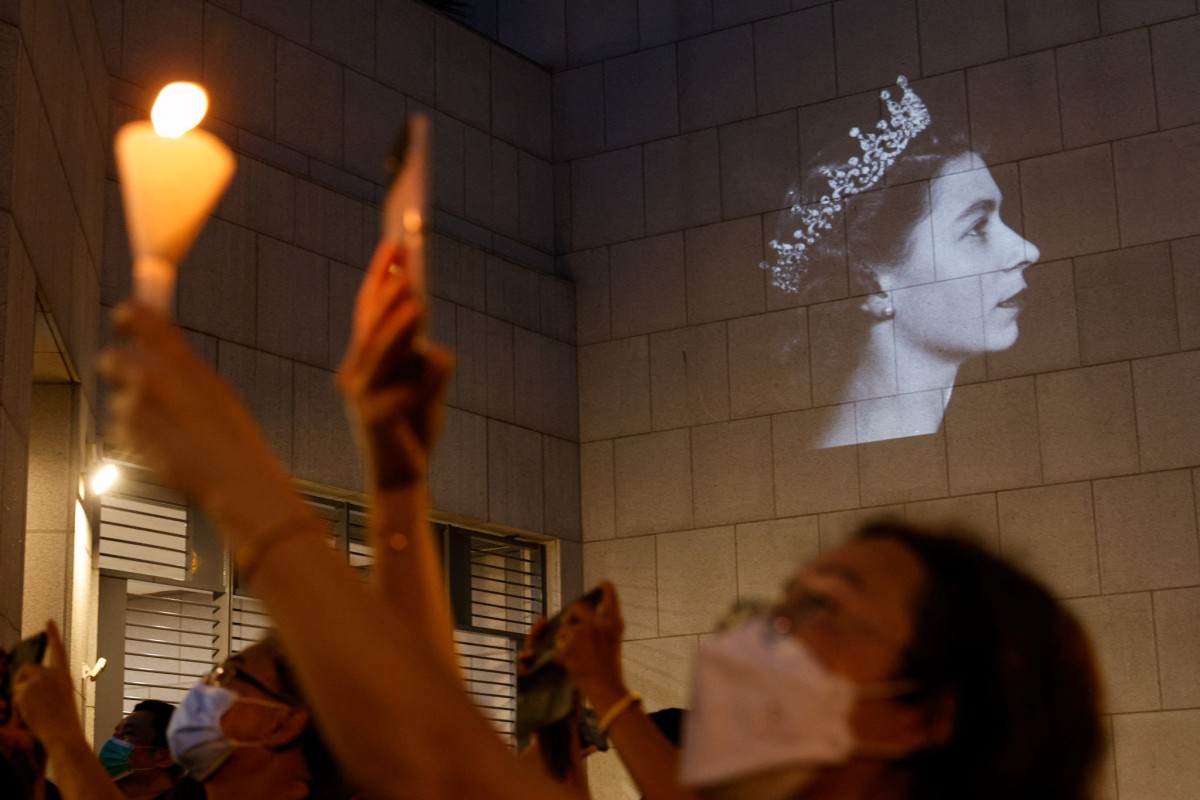 People hold candles during the funeral of Britain’s Queen Elizabeth outside the British consulate in Hong Kong. Photo: Reuters