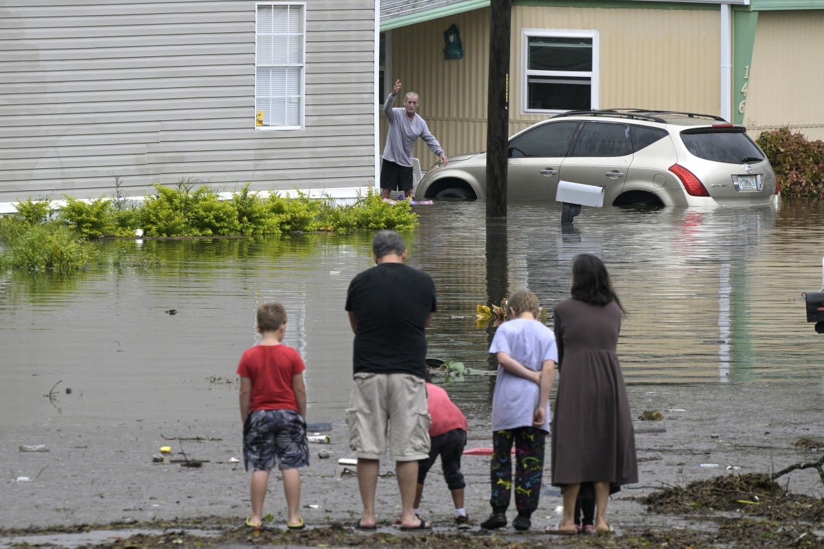 Residents check on one another in a flooded neighborhood in the aftermath of Hurricane Ian in the US state of Florida. Photo: AP