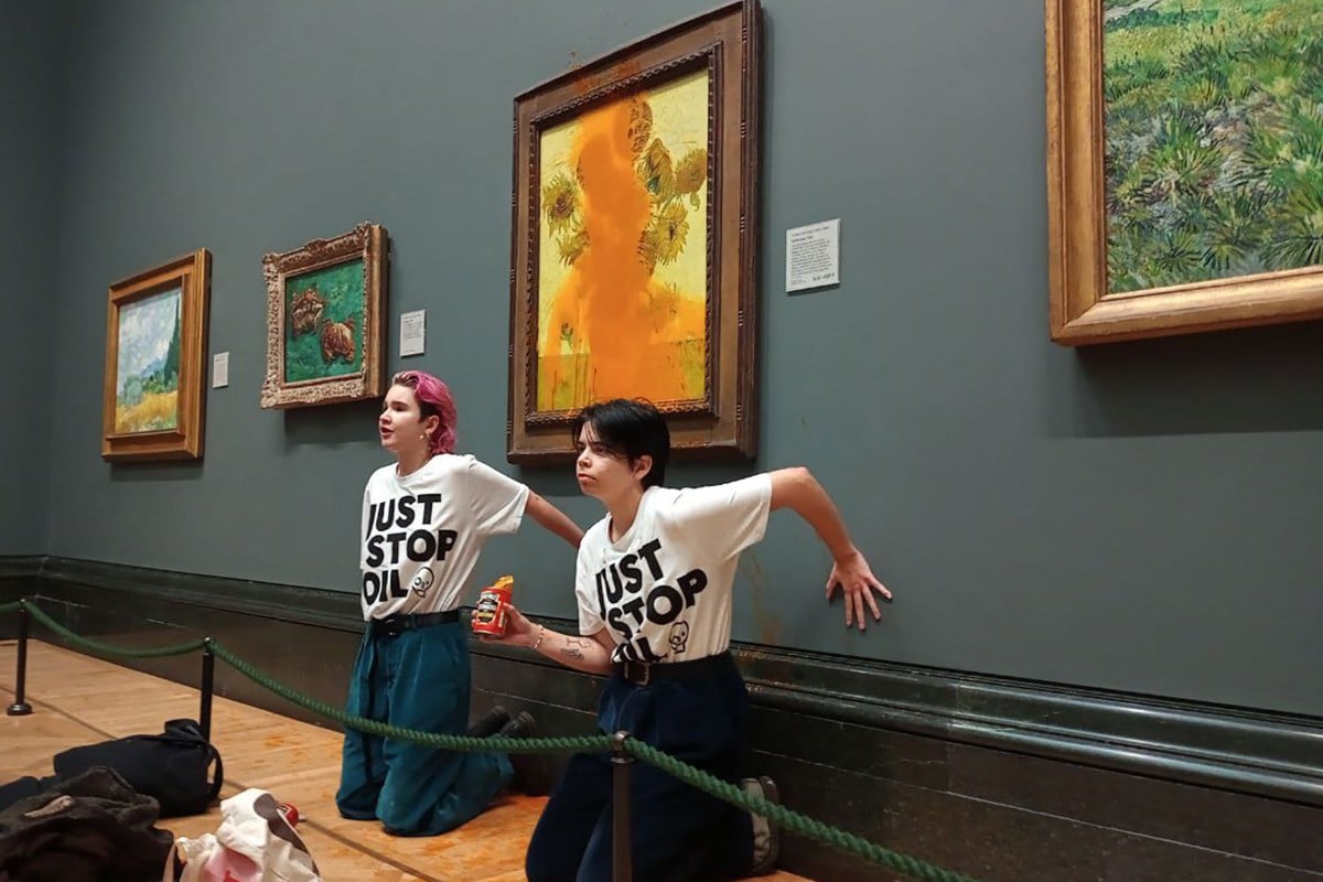 Activists glued their hands to the wall under Vincent van Gogh’s “Sunflowers” after throwing soup on the painting. Photo: Handout/ Just Stop Oil/ AFP