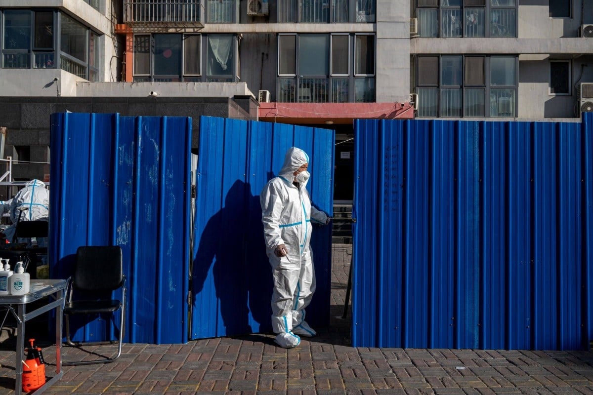 A worker in protective gear stands at a neighbourhood placed under lockdown due to Covid-19 in Beijing on Monday, November 21, 2022. Photo: Bloomberg