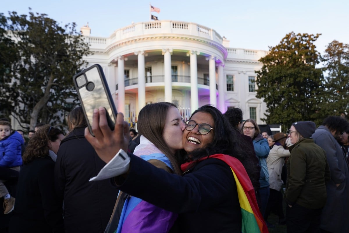 Aparna Shrivastava, right, takes a photo as her partner Shelby Teeter kisses her after President Joe Biden signed the Respect for Marriage Act on Tuesday, December 13, 2022. Photo: AP