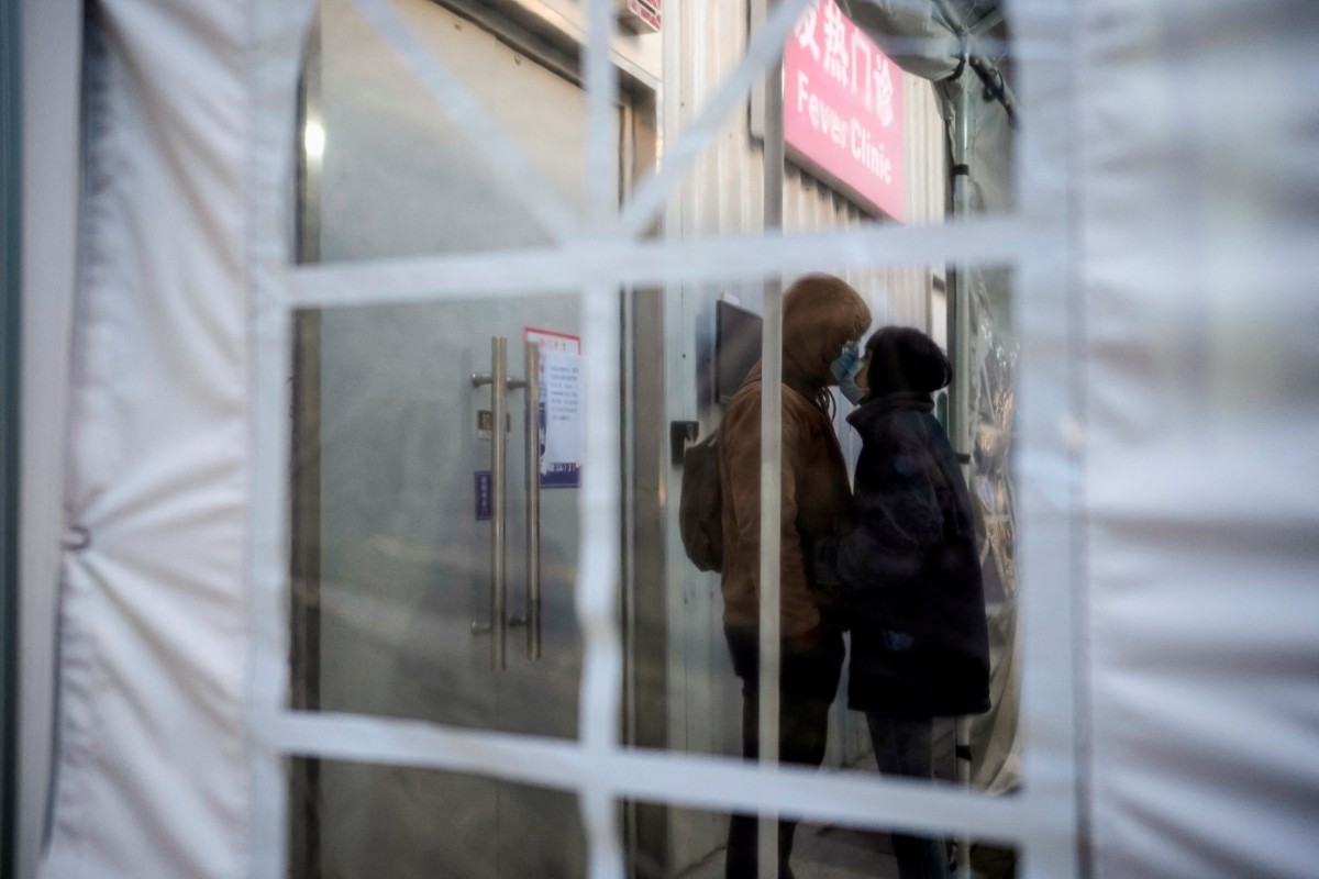 A couple wearing protective masks kisses at a fever clinic in Shanghai, China, on December 23, 2022. Photo: Reuters