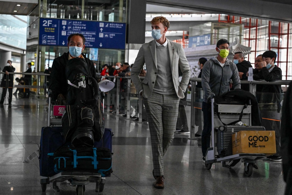 Passengers walk through the arrivals hall for international flights at the Capital International Airport in Beijing. Photo: AFP