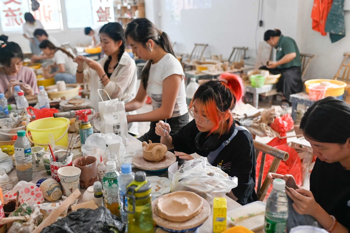 This picture taken on August 25, 2023 shows a group of people learning to make pottery at a workshop in Jingdezhen, in China’s Jiangxi province. The city has attracted droves of young people drawn in search of an escape from the urban rat race among its ceramics workshops. Photo: AFP