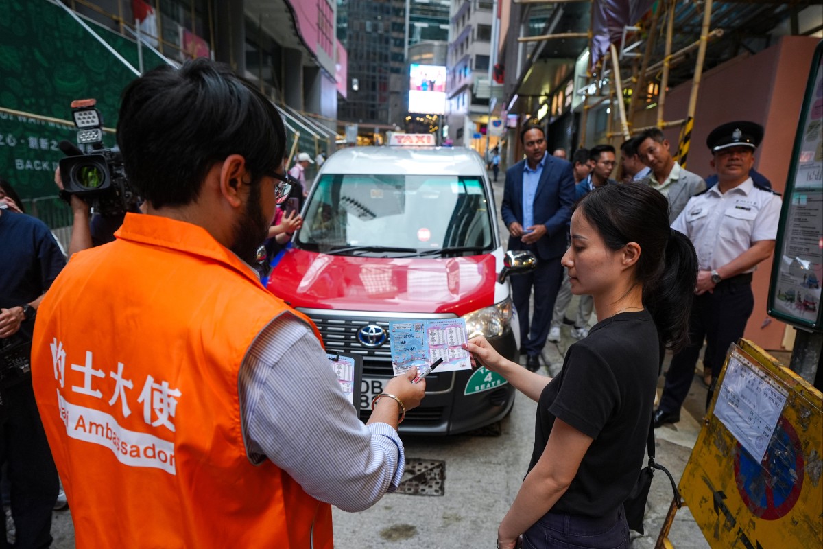 “Taxi ambassadors” will help passengers in Lan Kwai Fong fill out information about their rides. Photo: Eugene Lee