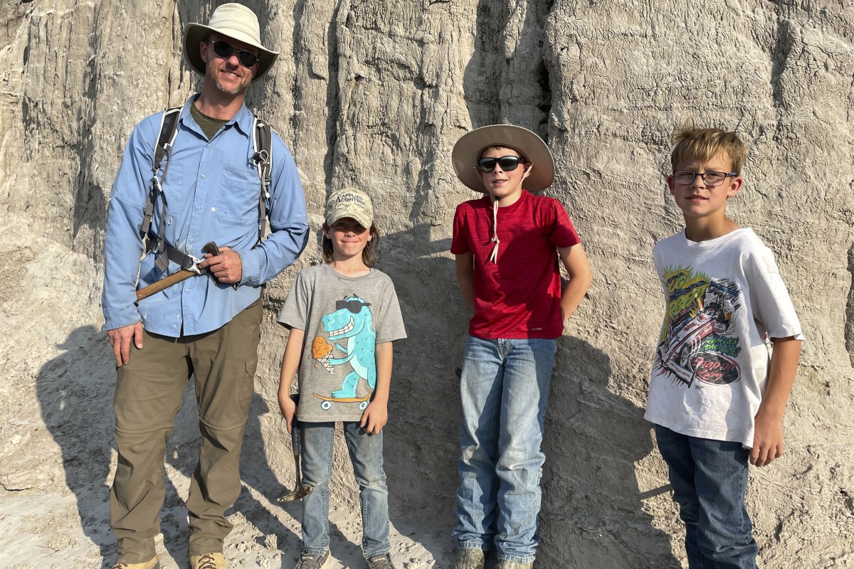 Vertebrate paleontologist Tyler Lyson (left) poses with young fossil finders on the day their expedition uncovered features of a juvenile T. rex. Photo: AP