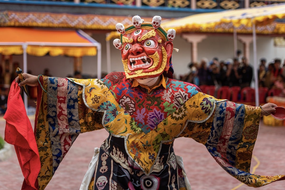 A monk wearing a colourful mask and clothes performs a ritual dance at the Takthok festival. Photo: Shutterstock