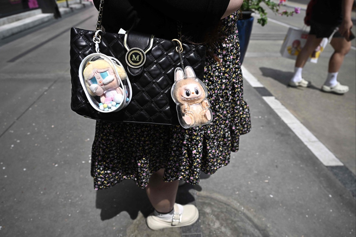 Designer art toys Labubu (R) and CryBaby (L) attached to a shopper’s handbag outside the Pop Mart store in Siam Square in Bangkok. Photo: AFP