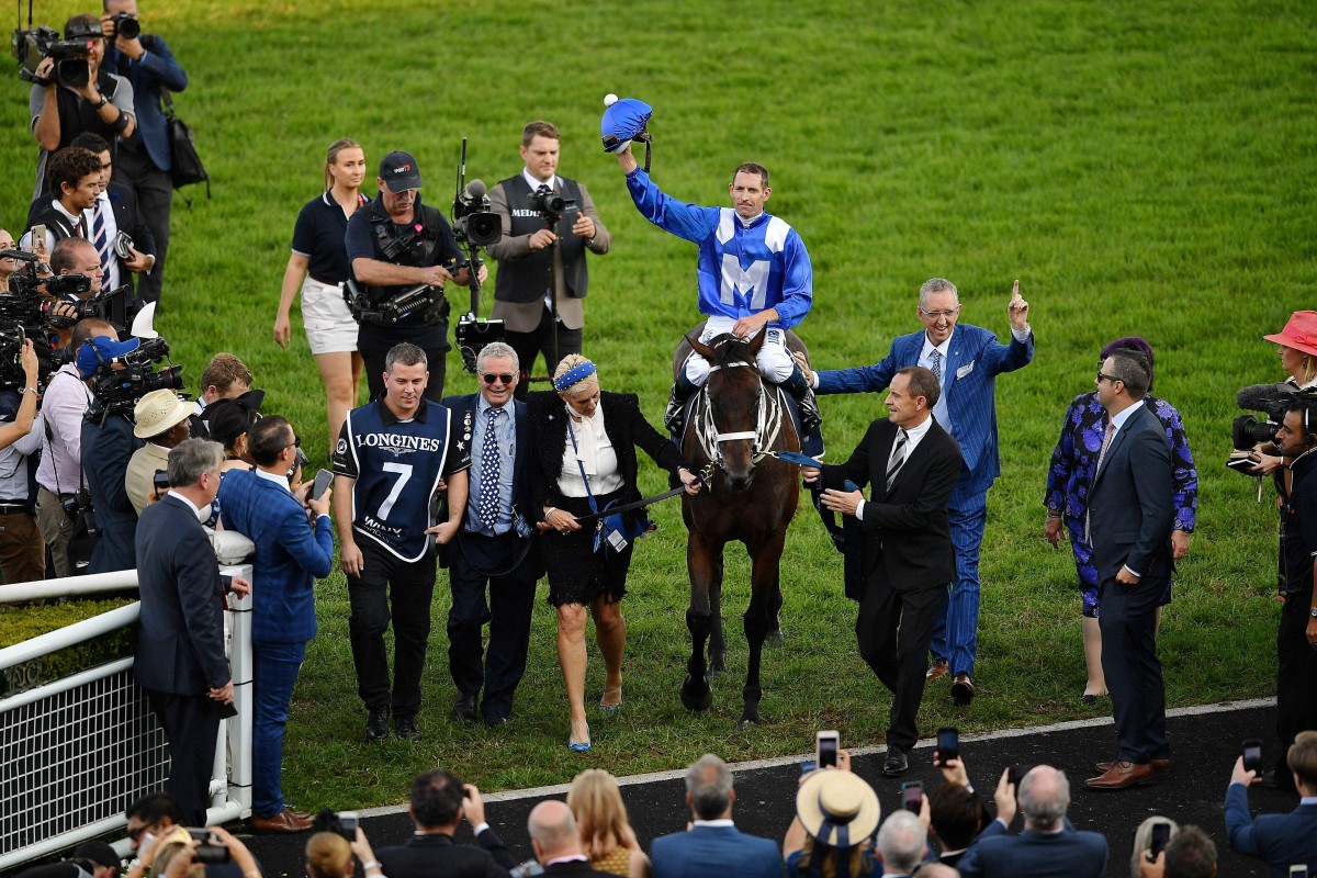 Jockey Hugh Bowman celebrates on the back of champion racehorse Winx after her final race to victory in the Longines Queen Elizabeth Stakes. Photo: AFP